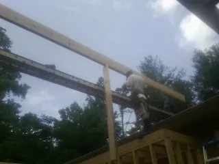 Carpenter setting a ridge beam over a new addition frame — Ice Dam Removal by Roofing Brothers in Fair Haven