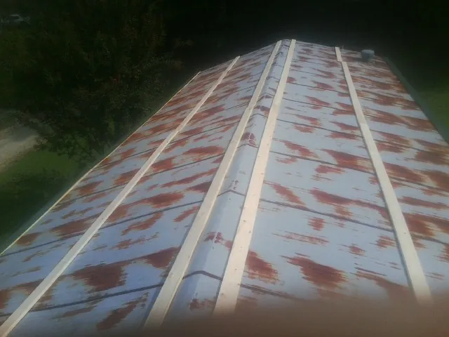 Rusted metal roof panels with new wood purlins before replacement — Storm Damage Roof Repair in Fair Haven by Roofing Brothers